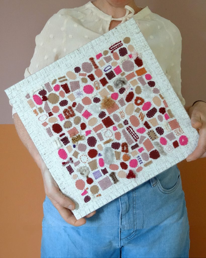 Dit werk heet Zoet zomerfruit en is 30x30 cm. Zoet zomerfruit is een herinnering aan zomerse dagen met een gouden randje. Annemieke heeft het werk schuin in haar handen.